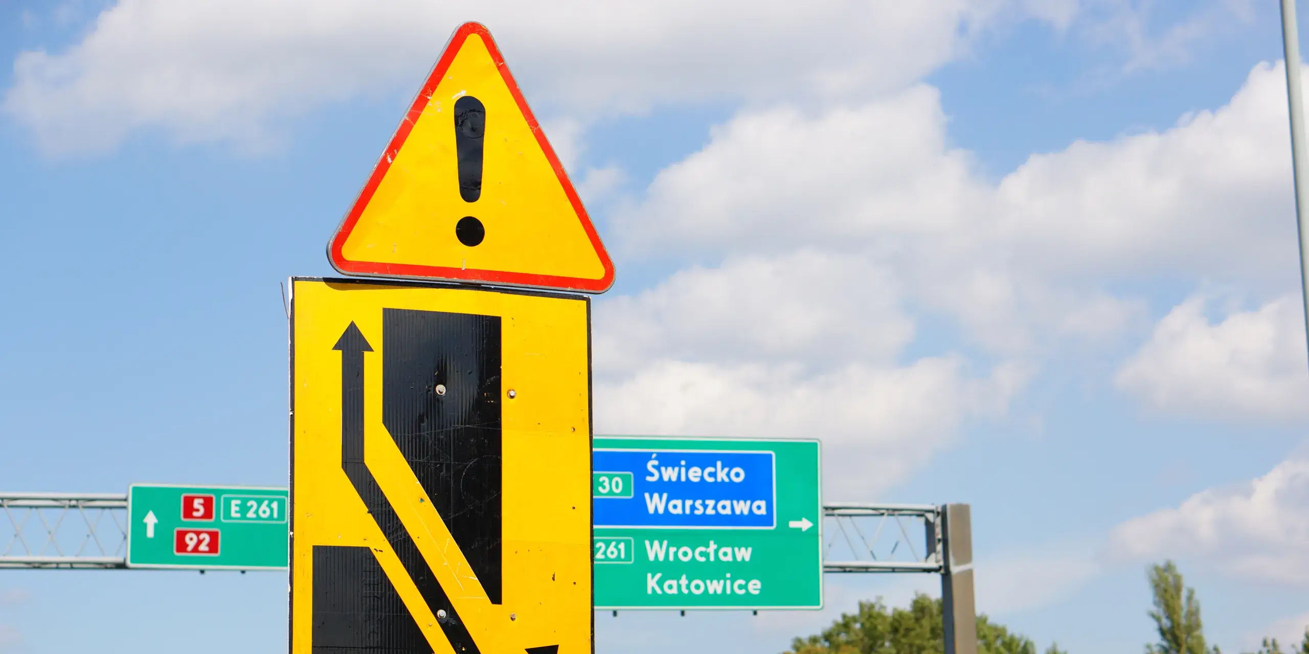 closeup-shot-of-yellow-road-warning-signs-on-a-blu-2023-11-27-05-10-06-utc